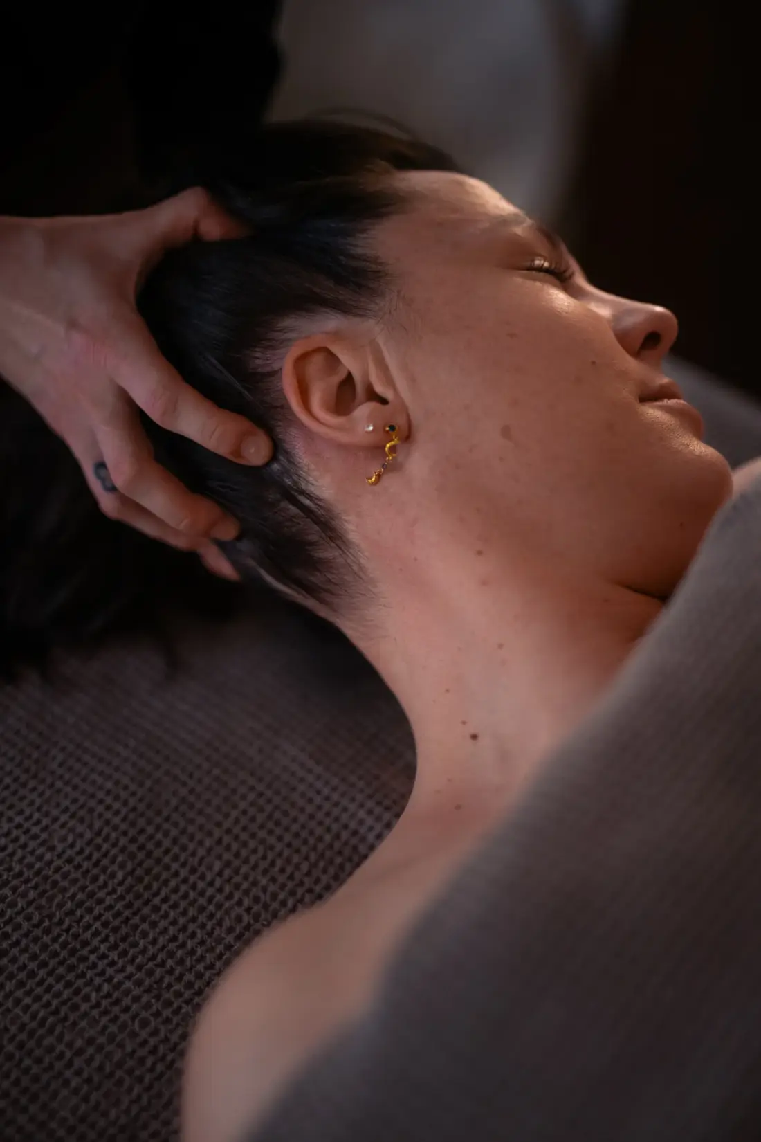 Supporting the back of the head and neck during gentle massage.