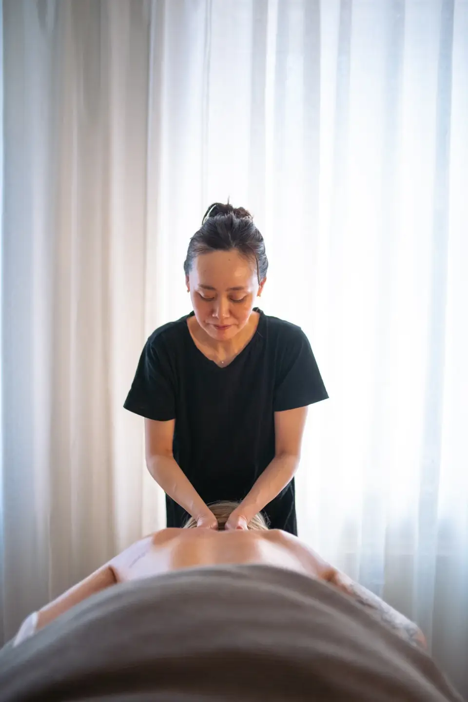Rygmassage med begge hænder set fra hovedenden hos manualtherapies på Frederiksberg.
