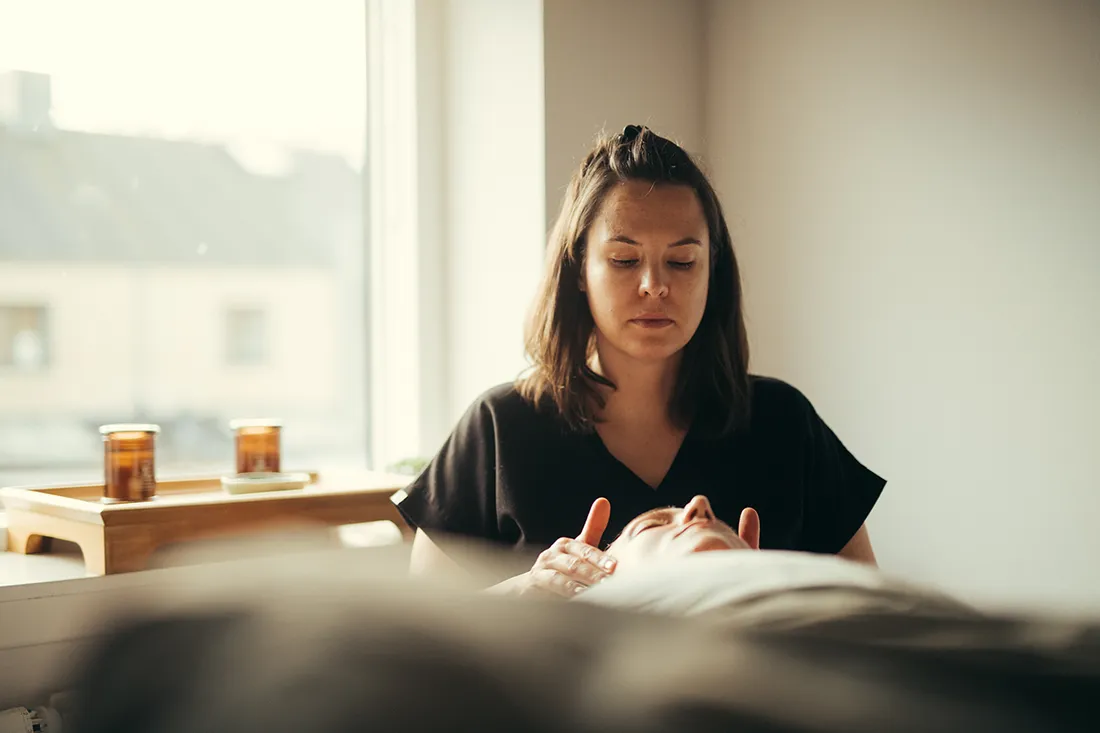 Terapeut udfører vagusnerven massage på en klient i en rolig klinik.